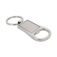 Prostokątny, metalowy brelok połączony z otwieraczem